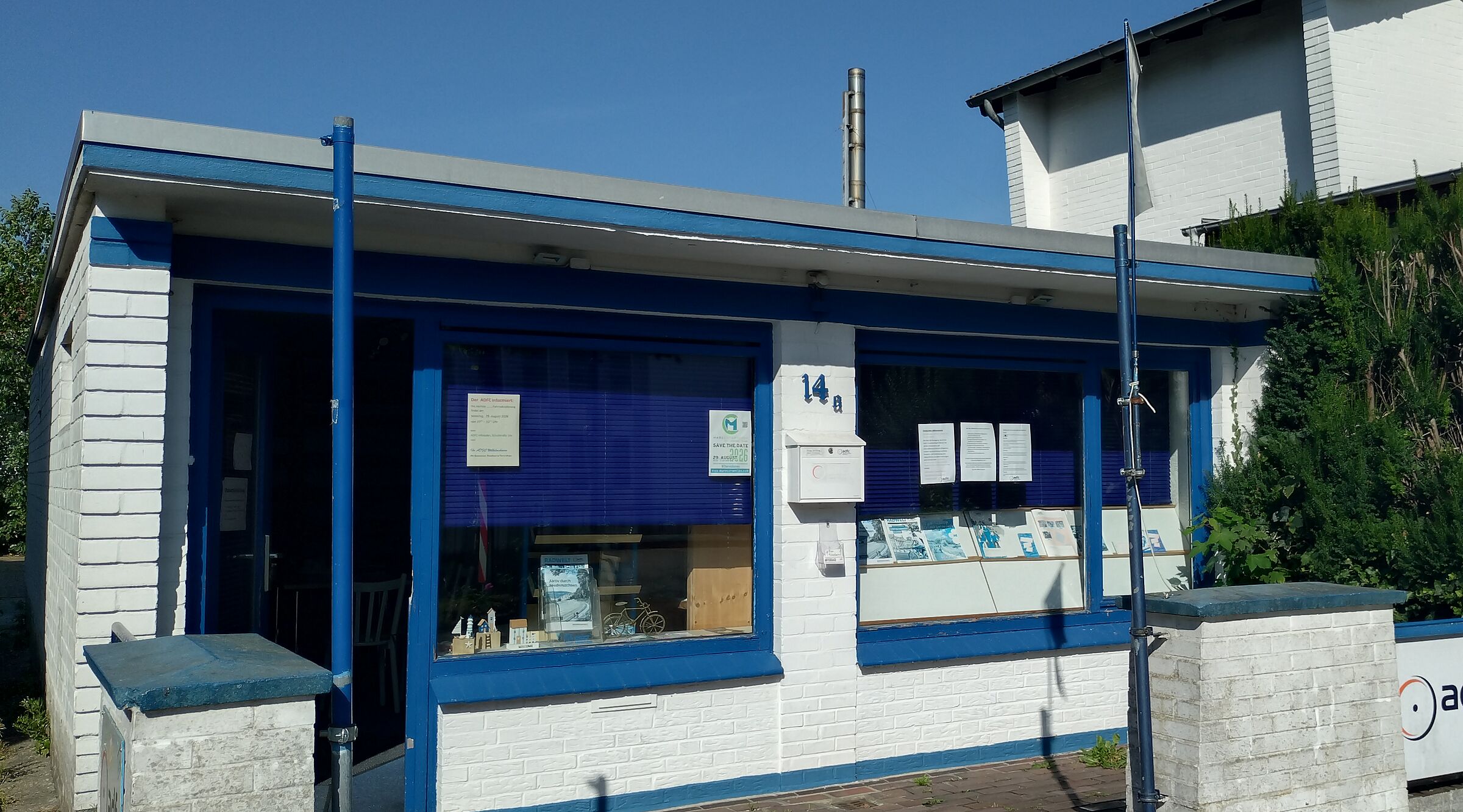 Ein weißer, gemauerter Bungalow mit blauen Tür- und Fensterrahmen.