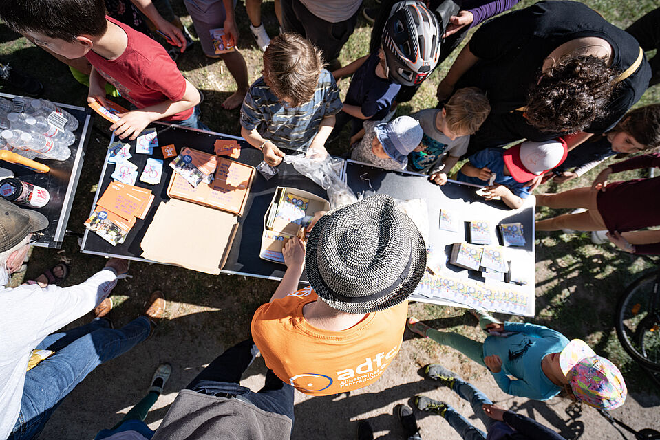 ADFC Infostand bei der Kidical Mass Hamburg 2022 Kinder und Erwachsene stehen verstammelt um einen Infostand.