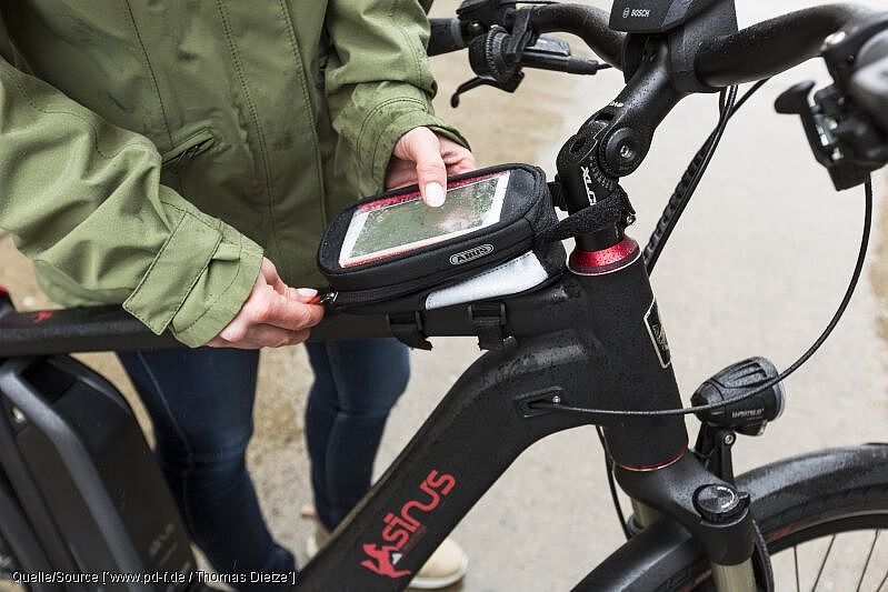 Smartphone-Taschen oder Lenkerhalterungen schützen das Telefon vor der Witterung.